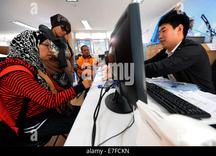 Incheon, Südkorea. 16. Sep, 2014. Ein Mitarbeiter Arbeitnehmer (R) macht Registrierung für malaysische Journalisten im Media Village der 17. Asian Games in Incheon, Südkorea, 16. September 2014. Das Medien-Dorf befindet sich in Guwol Dong, Incheon, 10 Kilometer entfernt von der Main Press Center. Es besteht aus 15 Wohnhäuser, die insgesamt 2.900 Zimmer. Die 17. Asian Games wird vom Sept. 19 Okt. 4 stattfinden. © Han Yuqing/Xinhua/Alamy Live-Nachrichten Stockfoto