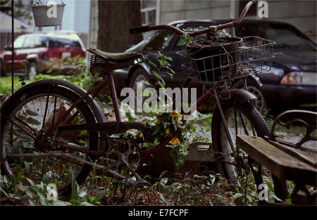 Rostigen alten Fahrrad als Blumengarten Dekoration an einem bewölkten Tag verwendet wird. Stockfoto