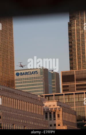 Flugzeug fliegen über Barclays Hauptquartier in Canary Wharf, London im September Stockfoto
