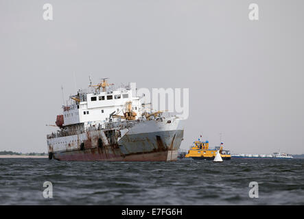 Verlassene Schiff in der Mitte eines Flusses Stockfoto