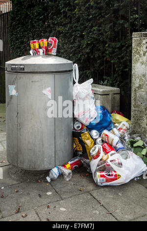 Überfüllte Mülltonne / Mülleimer mit Müll herum und Bier Dosen an der Spitze Stadtstraße gestapelt Stockfoto
