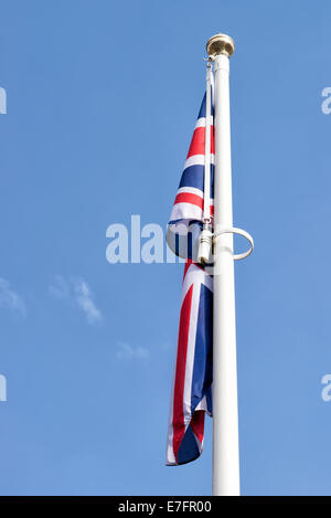 Union Flag erscheint schlaff und welk auf einem Fahnenmast Stockfoto