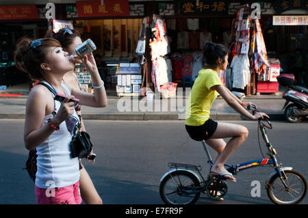 Kleine Geschäfte in der Altstadt, Shanghai, China Mädchen und Mädchen mit dem Fahrrad spazieren. Die Altstadt von Shanghai, Shanghai Lă Stockfoto