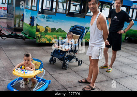 Väter nehmen Auto seiner Kinder in den Straßen von Shanghai. Shanghai hat einiges zu bieten Ihre Kinder, wenn sie müde Stockfoto