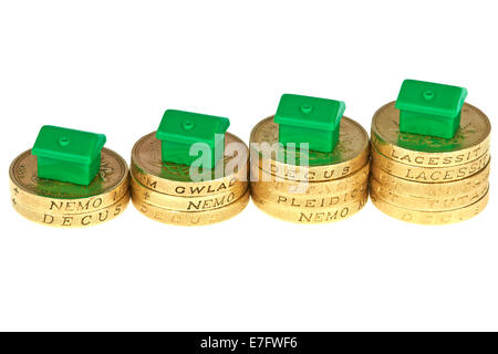 Monopol Häuser auf Rising Haufen Pfund-Münzen Stockfoto