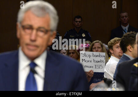 Washington, DC, USA. 16. Sep, 2014. Anti-Kriegs-Aktivisten protestieren als US-Verteidigungsminister Chuck Hagel (vorne) kommt vor dem Senate Armed Services Committee auf dem Capitol Hill in Washington, DC, USA, 16. September 2014 bezeugen. Es ist die erste hochkarätige Anhörungen Prüfung Präsident Barack Obama Strategie zur Bekämpfung des islamischen Staates Extremisten im Irak und in Syrien. Bildnachweis: Yin Bogu/Xinhua/Alamy Live-Nachrichten Stockfoto