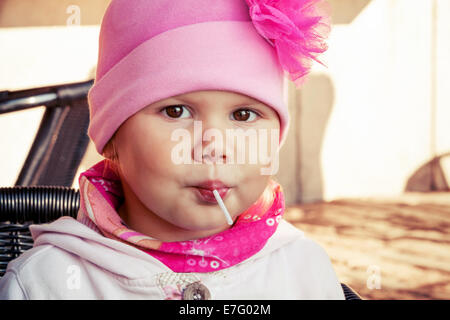 Closeup Portrait von Babymädchen in rosa Essen Lutscher Stockfoto