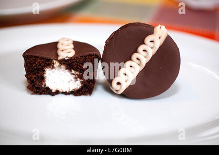 Hostess Cupcakes. Hostess Cupcakes bestehen Schokoladenkuchen mit cremigen Füllung im Inneren und einer Wellenlinie Sahnehäubchen-Linie durch die Stockfoto