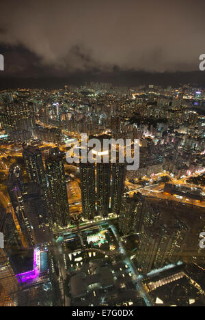 Blick hinunter auf Hong Kong und Kowloon an einem dunklen, trüben Abend. Stockfoto