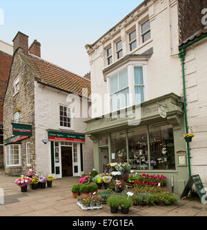 Blumenladen mit Schnittblumen und Töpfe mit bunt blühenden Pflanzen auf Bürgersteig im englischen Dorf von Pickering Stockfoto