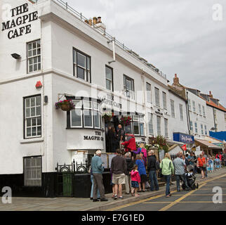 Lange Schlange von Menschen außerhalb Award Magpie Cafe, traditionelles Gericht mit Fisch und Chips in englischen Küsten Stadt Whitby zu kaufen Stockfoto