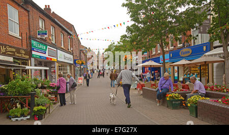 Fußgängerzone mit Käufern an Ständen und bunten Displays von Blumen im englischen Stadt Congleton durchsuchen Stockfoto