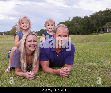 Junge Familie auf dem grünen Rasen legen.  Clermont-Florida-USA Stockfoto