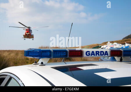 Irish Coast Guard IRCG Garda Cósta Na hÉireann Sikorsky Hubschrauber fliegt über eine irische Polizeiauto während einer medizinischen Rettung Stockfoto