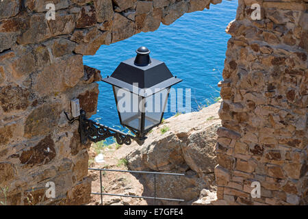 Straßenlaterne an der Wand über den Pass in Festung "Vila Vella Umwehrung" der Altstadt in Tossa de Mar, Costa Brava, Katalonien. Stockfoto