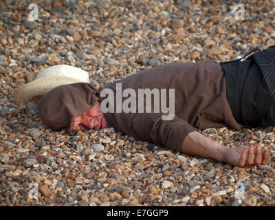 Ohnmächtig, schläft ein betrunkener es sich am Strand von Brighton Stockfoto