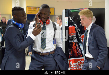 Wolfsburg Spieler Junior Malanda (L), Josuha Guilavogui und Kevin De Bruyne warten auf ihre Koffer am Flughafen in Liverpool, Großbritannien, 17. September 2014. Der VfL Wolfsburg spielt gegen den FC Everton in Liverpool am 18. September 2014. Foto: Peter Steffen/dpa Stockfoto