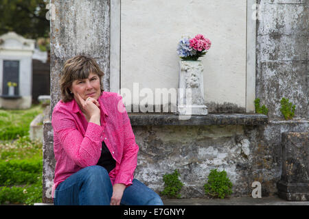 Frau im historischen Friedhof von New Orleans.  Blick in die Kamera.  Kopieren Sie Speicherplatz auf Krypta, wenn nötig. Stockfoto