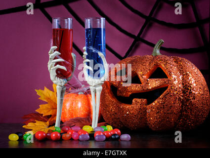 Happy Halloween schaurige Party Cocktails mit Spinnennetz und Dekorationen auf lila Hintergrund. Stockfoto