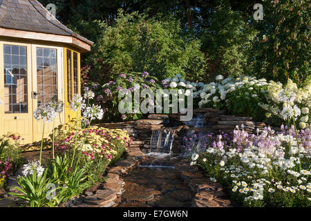 Garten - Wasser-Garten - Laube neben Wasserfall Wasserspiel Pflanzung Agapanthus "Queen Mum" Hydrang Stockfoto