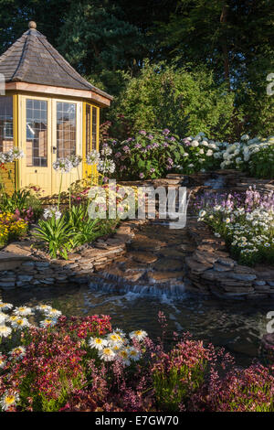 Garten - Wasser-Garten - Laube neben Wasserfall Wasserspiel Pflanzung Agapanthus "Queen Mum" Stockfoto