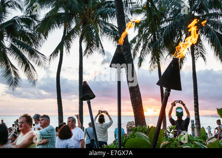 Hawaii, Hawaiian, Honolulu, Waikiki Beach, Kuhio Beach Park, Pazifischer Ozean, Sonnenuntergang, Waikiki Bay, Palmen, Tiki Laternen, beleuchtet, Feuer, USA, USA, USA, Amerika Stockfoto