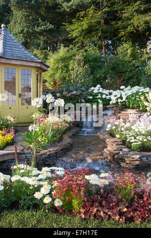 Garten - Wasser-Garten - Laube neben Wasserfall Wasserspiel Pflanzung Agapanthus "Queen Mum" Hydrang Stockfoto