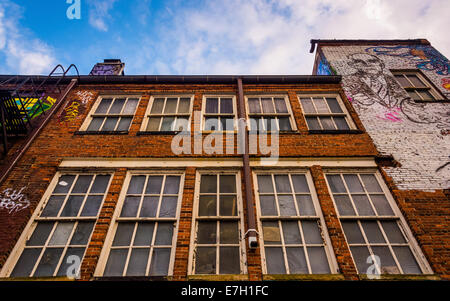 Fenster an der Seite eines Gebäudes in Graffiti Gasse, Baltimore, Maryland. Stockfoto