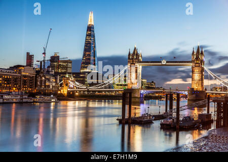 Nachtansicht des St Katherines Pier, Tower Bridge auf die Scherbe in London mit leuchtenden Farben und dramatischen Wolkenhimmel Stockfoto