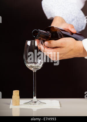 Männliche Kellner oder Butler Portion Weißwein in Glas gießen. Stockfoto