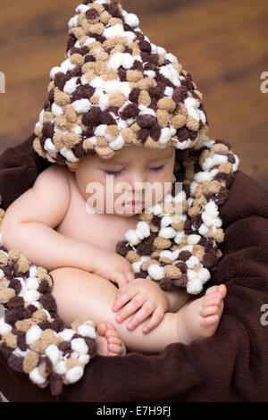 Baby Boy in einem Korb mit Mütze und Schal Stockfoto