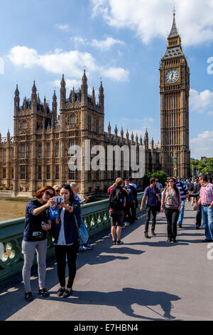 Touristen posieren vor den Houses Of Parliament und Big Ben, London, England Stockfoto