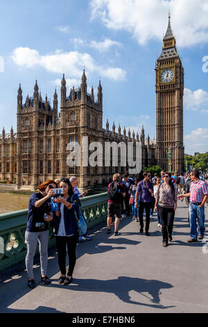 Touristen posieren vor den Houses Of Parliament und Big Ben, London, England Stockfoto