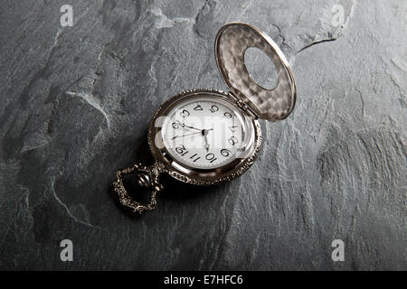 Tasche grau Uhr auf dunkle graue Schiefer Textur Stockfoto