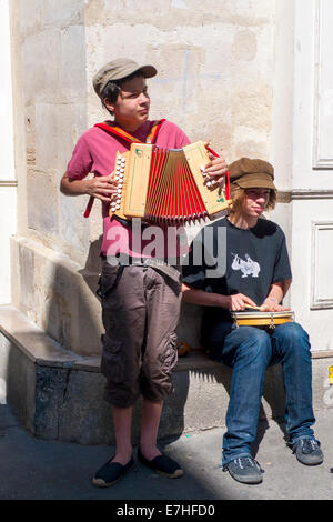 Junge Straßenmusiker spielen ein Akkordeon und ein Tamburin auf den Straßen von Paris Stockfoto