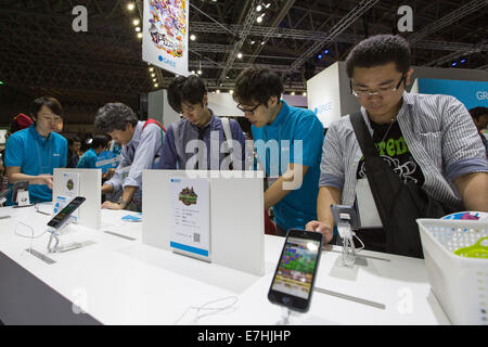 Chiba, Japan. 18. Sep, 2014. Besucher spielen Handyspiele von Gree auf die 2014 Tokyo Game Show auf der Makuhari Messe, östlich von Tokio, am Donnerstag, 18. September 2014 eröffnet. Die jährliche Ausstellung bietet fast 750 Spiele von 400 Ausstellern für jede Art von Konsole, Smartphone und Tablet. Asiens größte Gaming-Messe wird voraussichtlich mehr als 200.000 Besucher während der vier Tage zu ziehen. Bildnachweis: AFLO/Alamy Live-Nachrichten Stockfoto