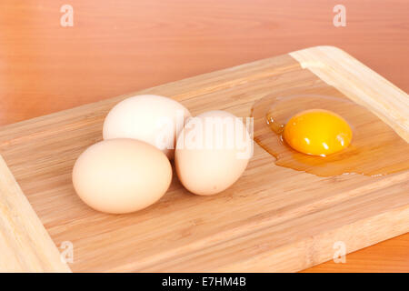 Drei braunen Eiern Closeup und eins auf hölzernen Hintergrund gebrochen Stockfoto
