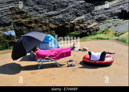 Mann verdeckt auf britischen Strand für den Sommer-Besuch Stockfoto