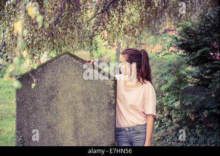 Vintage-Shooting einer Frau berühren einen Grabstein Moos bewachsen. Stockfoto