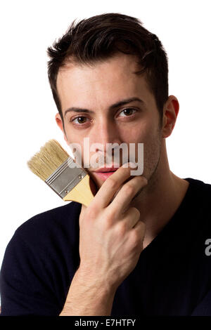 Mann hält einen Pinsel in der hand und denken über weißen Hintergrund isoliert Stockfoto