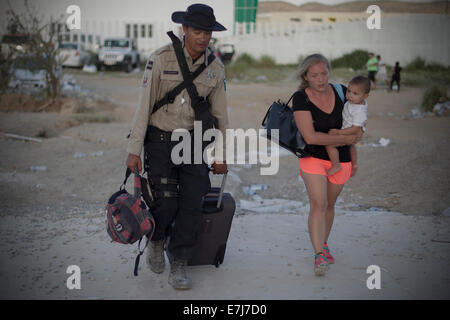 Los Cabos, Mexiko. 18. Sep, 2014. Ein Element der Gendarmerie hilft Touristen nach dem Ableben von Hurrikan Odile in Los Cabos, im Bundesstaat Baja California Sur, Mexiko, 18. September 2014. Laut offiziellen Regierung werden Touristen in Guadalajara, Tijuana, Mazatlan und Mexiko-Stadt transportiert werden. Die Flughäfen von Los Cabos und La Paz, zwei Städte auf der Halbinsel wurden durch Odile, die auch Links Dutzende Häuser und kommerziellen Einrichtungen, sowie umgestürzte Bäume, Strommasten und Plakate betroffen beschädigt. Bildnachweis: Alejandro Ayala/Xinhua/Alamy Live-Nachrichten Stockfoto