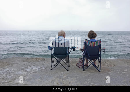 Ein paar sitzen am Meer in Falmouth, Cornwall Stockfoto