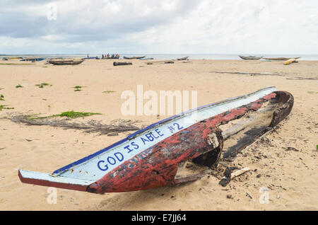 Hölzerne Angelboot/Fischerboot zerstört am Strand Robertsport, Liberia, lesen "Gott ist in der Lage" Stockfoto