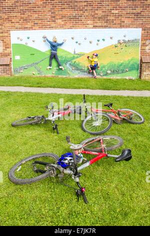 Kinder spielen an einer Kletterwand neben Zyklen auf dem Thornbridge im freien Bike Festival in großen Longstone nr Bakewell Stockfoto