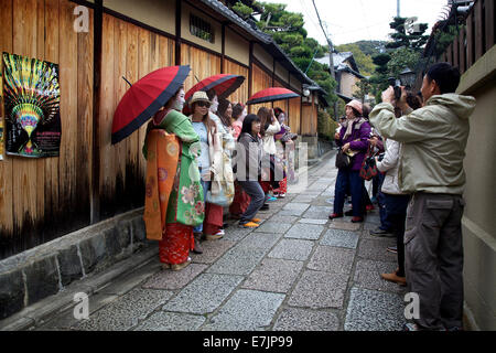 Japanische Frauen, Geishas, posiert für ein Foto mit Touristen, Gion Bereich, Kyoto, Japan, Asien. Traditionelle Geisha Make-up und Kleidung Stockfoto