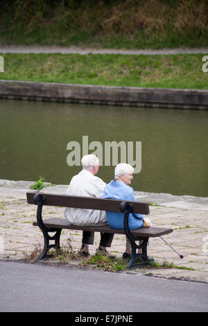 Ein älteres Paar saß im August auf einer Bank in Devizes, Wiltshire, Großbritannien Stockfoto