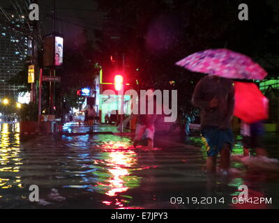 Manila, Philippinen. 19. September 2014. Fast einen Kilometer Espana Blvd. ist überflutet und meist nicht durchgängig durch Gosse tiefen Fluten von tropischer Sturm Fung Wong bekannt als Mario lokal gebracht. Einige Fahrzeuge und gestrandete Fluggäste haben den Mut, die schrecklichen Fluten entlang der Strecke von Espana Blvd. zu durchqueren Seine geschätzte Niederschlagsmenge ist von 7-20 mm pro Stunde (mäßige bis intensive) innerhalb der stropical Sturm 350 km Durchmesser. Bildnachweis: Sherbien Dacalanio / Alamy Live News Stockfoto