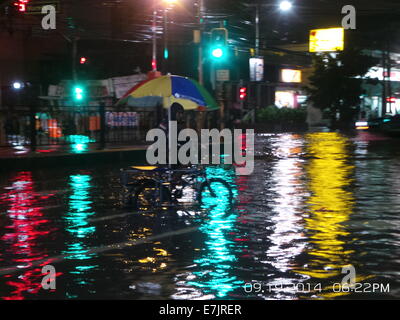 Manila, Philippinen. 19. September 2014. Fast einen Kilometer Espana Blvd. ist überflutet und meist nicht durchgängig durch Gosse tiefen Fluten von tropischer Sturm Fung Wong bekannt als Mario lokal gebracht. Einige Fahrzeuge und gestrandete Fluggäste haben den Mut, die schrecklichen Fluten entlang der Strecke von Espana Blvd. zu durchqueren Seine geschätzte Niederschlagsmenge ist von 7-20 mm pro Stunde (mäßige bis intensive) innerhalb der stropical Sturm 350 km Durchmesser. Bildnachweis: Sherbien Dacalanio / Alamy Live News Stockfoto