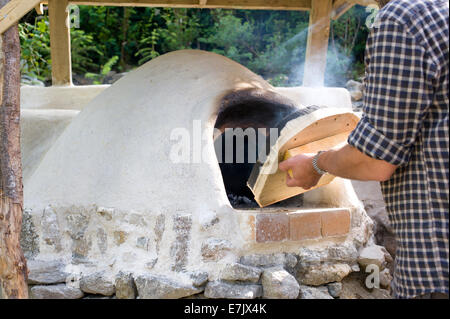 Erde-Ton-Cob-Ofen-Projekt.  Der Ofen wurde endlich und jetzt fertig gestellt um das Feuer im Inneren zu überprüfen Stockfoto