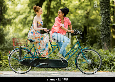 Junge Frauen fahren auf dem Fahrrad Stockfoto